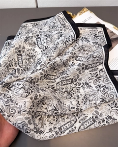 Detailed view of paisley pattern scarf with black border and soft fabric texture