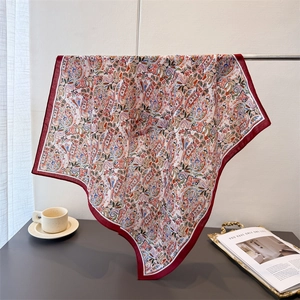 Elegant red paisley silk-like square scarf with floral pattern shown in a lifestyle setting