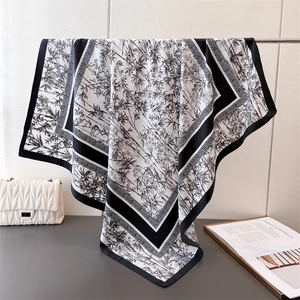 Detail of bamboo print silk scarf showing smooth texture and elegant drape on a rack