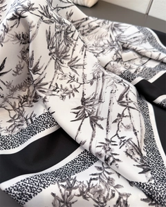 Detail of silk scarf showing black bamboo ink print on white fabric with soft folds
