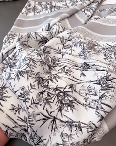 Macro detail of silk-like scarf featuring traditional black bamboo ink painting patterns