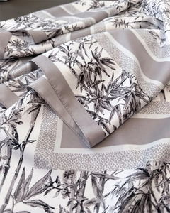 Close-up of silk-textured scarf showing elegant bamboo print and premium satin finish