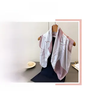 Detail of elegant pink and purple silk-like scarf with leaf pattern on a wooden hanger