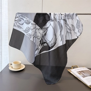 Elegant black and white silk scarf with horse and leaf print on a metal stand