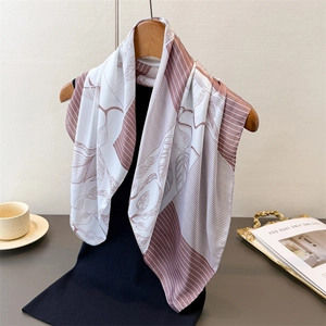 Elegant silk-like scarf with leaf prints hanging on a hanger in a lifestyle setting