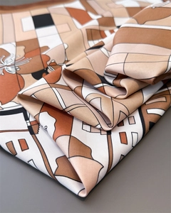 Détail macro d'un foulard en soie à motifs géométriques montrant sa texture lisse