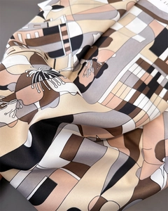 Gros plan détaillé montrant la texture sergée soyeuse et l'imprimé floral du foulard carré