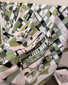Détail d'un foulard en soie avec motifs géométriques et imprimé floral vert