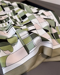 Détail montrant la texture soyeuse et le motif géométrique moderne du foulard carré