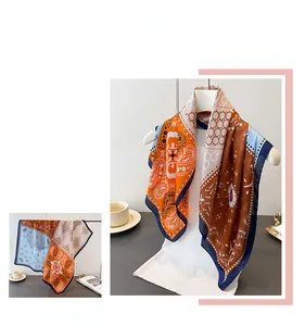 Detail of printed silk scarf with paisley and geometric patterns in orange and blue