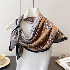 Detail of silk-like scarf with paisley and Eiffel Tower prints on a mannequin neck