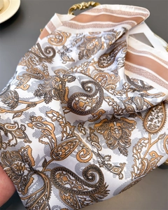 Detailed macro view showing the glossy silk-like fabric with golden paisley patterns