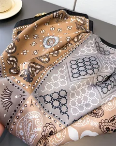Detailed view of color-block silk scarf with paisley and geometric patterns