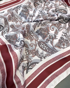 Macro detail of bordeaux red paisley print and silky texture on a vintage square scarf