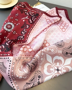 Detailed close-up of paisley and Eiffel Tower print on luxury burgundy silk square scarf