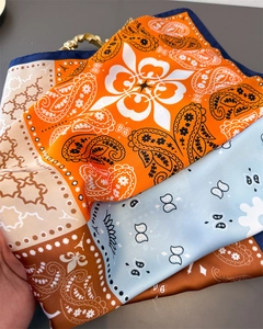 Detail of silk-like square scarf featuring colorful paisley prints and Eiffel Tower motifs