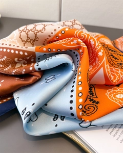 Close-up of silk scarf showing paisley pattern, butterfly prints and color blocking