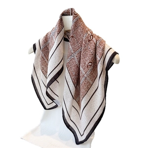Elegant paisley and plaid square scarf in brown and beige colors on a mannequin