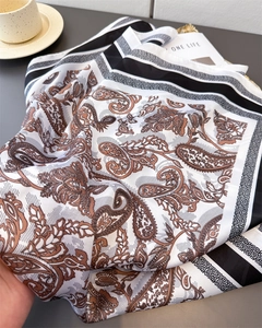 Close-up of silk-like paisley square scarf showing soft folds and smooth texture