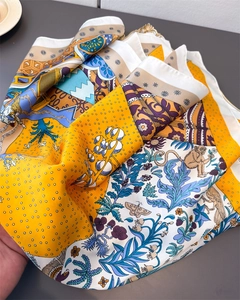 Vue détaillée du foulard en soie orange avec des imprimés élégants d'animaux et de fleurs