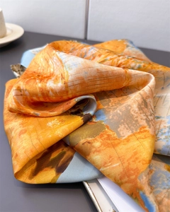 Détail d'un foulard en soie aux motifs de peinture à l'huile orange et bleus
