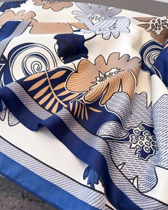 Macro detail of faux silk scarf showing vibrant floral patterns and lustrous texture