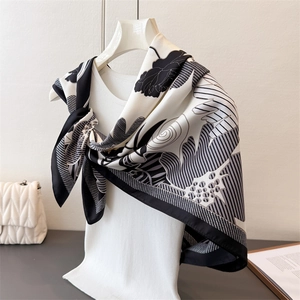 Elegant black and white floral satin silk scarf draped on a model in a minimalist setting
