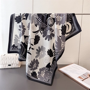 Detail showing hand-drawn floral silk scarf texture with black and white floral pattern