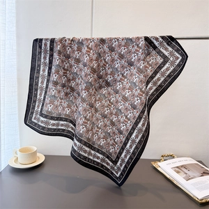 Detail view of oversized vintage paisley square scarf with silk-like finish and dark border