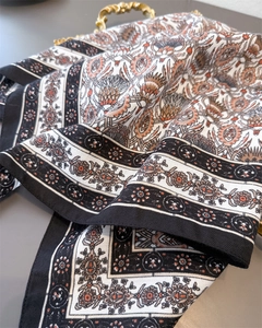 Close-up of vintage herringbone pattern silk scarf with floral bohemian print textures
