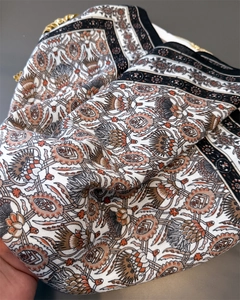 Close-up of vintage herringbone silk scarf with floral patterns and gold metal charms