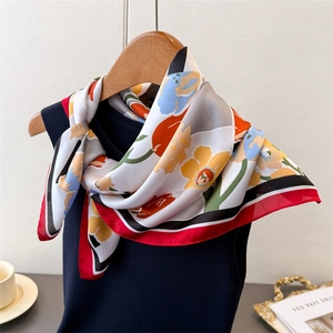 Artistic floral silk scarf tied on a vest, showcasing its smooth texture and vibrant pattern