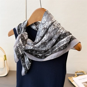 Elegant herringbone silk feel square scarf with vintage pattern draped on a wooden hanger