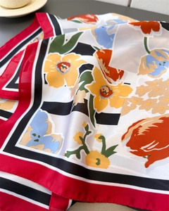 Detail of floral silk scarf with vibrant orange flowers and bold black stripes