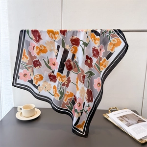 Floral print satin silk square scarf with striped patterns displayed on a metal stand