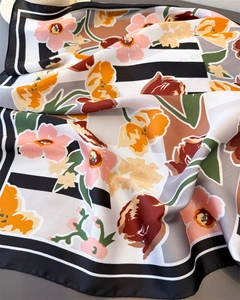 Detail of floral silk scarf showing fine rolled edges and satin fabric texture