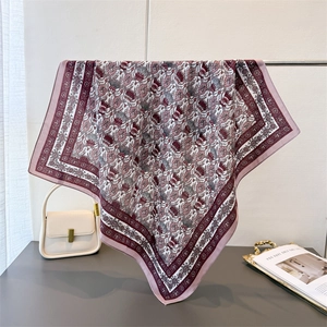 Detailed drape of vintage burgundy floral silk square scarf hanging on a metal rack