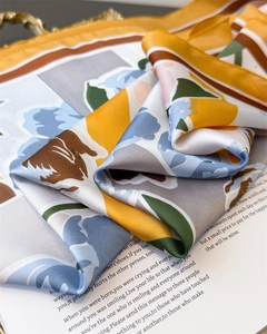 Close-up of floral silk-feel scarf with elegant satin finish on a magazine