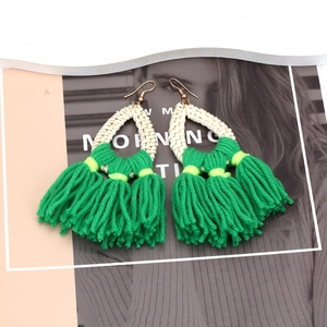 Bohemian handmade rattan earrings with vibrant emerald green fringes and yellow accents