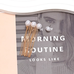 Asymmetric gold metal chain tassel earrings with pearls on a stylish magazine layout