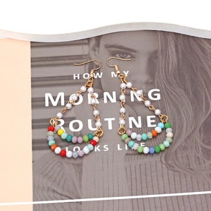 Bohemian multilayer beaded earrings with colorful crystals and faux pearls on a magazine