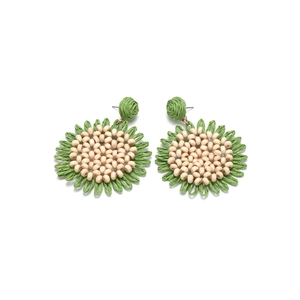 Detail of handmade woven raffia sunflower earrings with green straw and beige beads