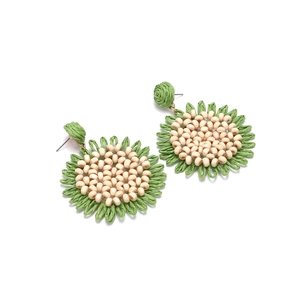 Detailed view of hand-woven raffia sunflower earrings with wooden bead centers