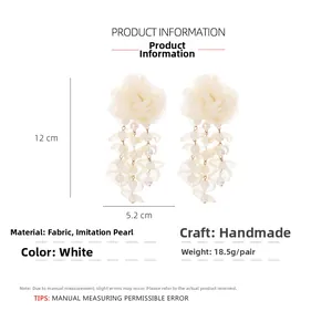 Detail of handmade white mesh flower earrings with pearls showing 12cm length and size