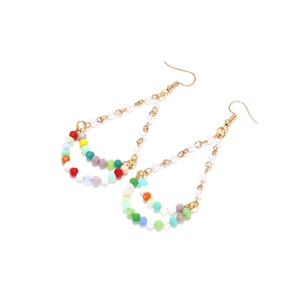 Bohemian multi-color beaded drop earrings with faux pearls and golden hooks on white surface