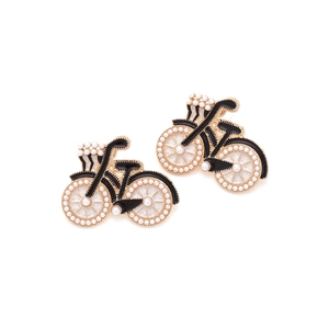 Détail des boucles d'oreilles vélo avec finition dorée, émail et perles d'imitation