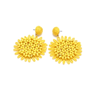 Detail of yellow woven sunflower earrings with central beadwork in Bohemian style