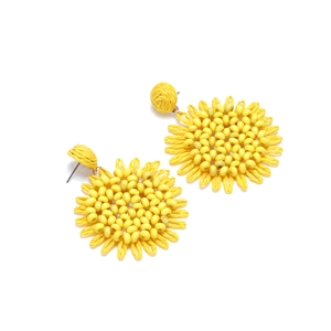 Detail view of handmade yellow raffia sunflower earrings with beaded centers