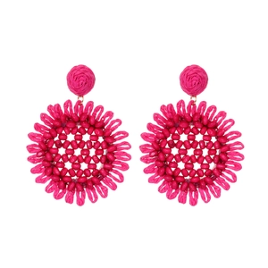 Handmade magenta raffia sunflower earrings in bohemian style on white background