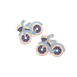Détail de boucles d'oreilles vélo avec émail bleu et perles sur cadre doré